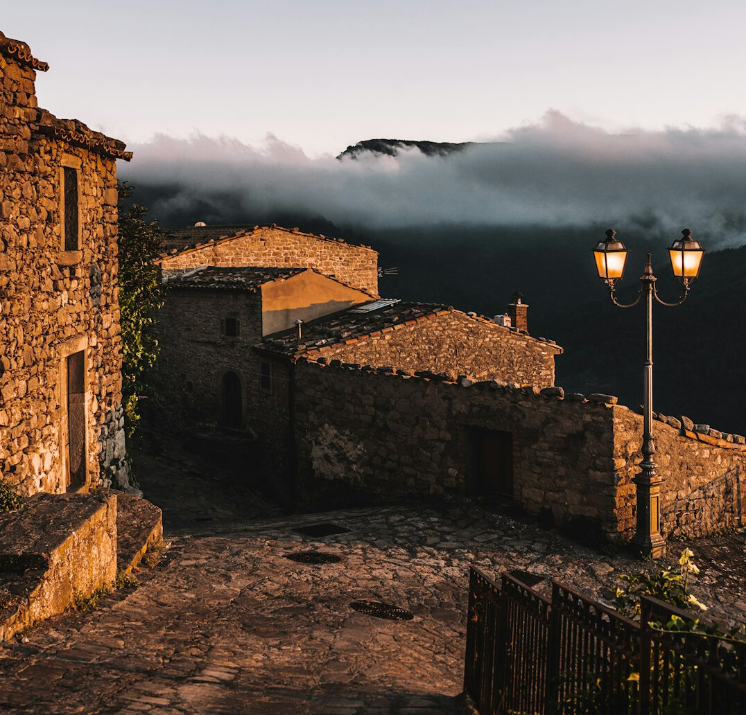 Photographer walking through a quiet Polish village street at dawn
