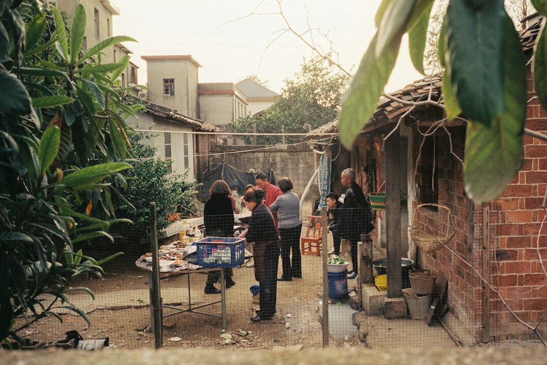 Photographer interviewing an elderly woman in a village home